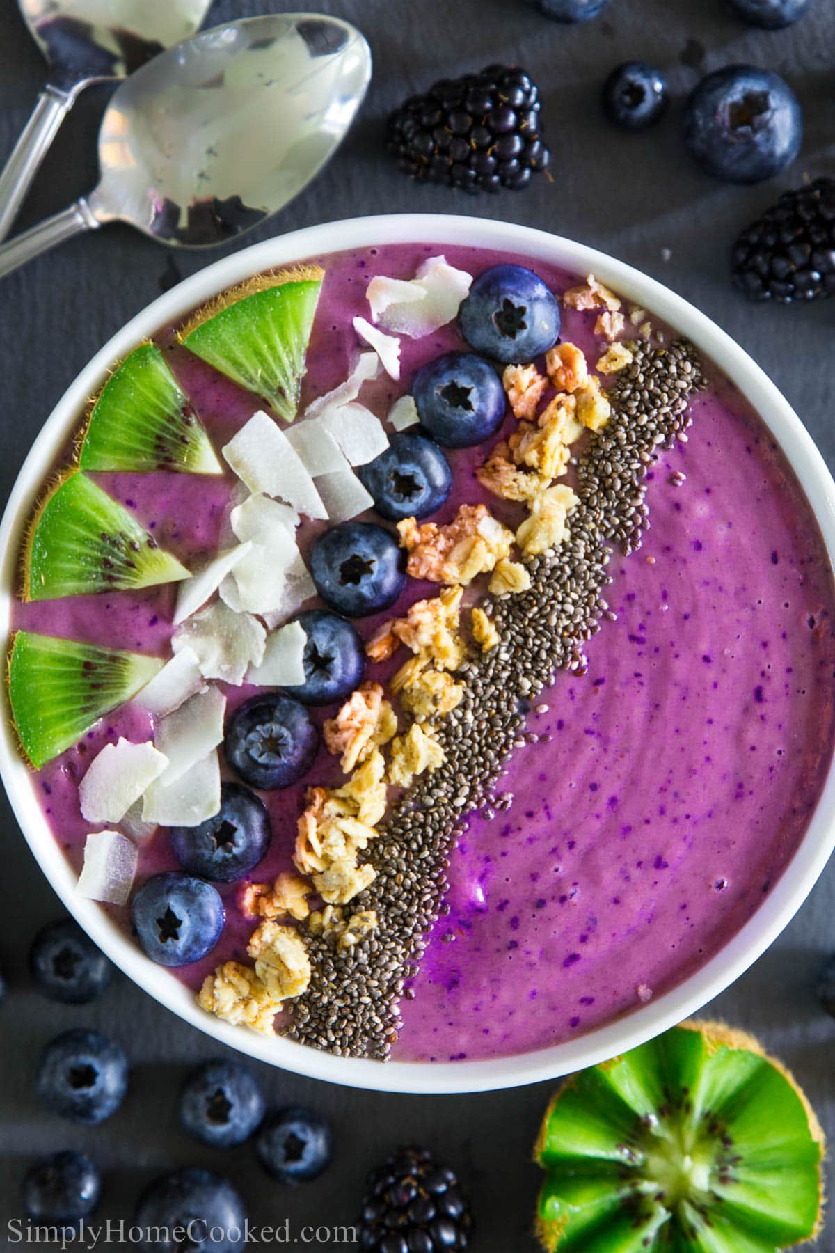 Blueberry Smoothie Bowl topped with kiwi slices, coconut flakes, blueberries, granola, and chia seeds.