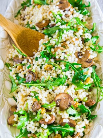 Couscous Arugula Salad and a wooden spoon.