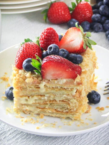 Slice of Easy Napoleon Cake topped with fresh berries.