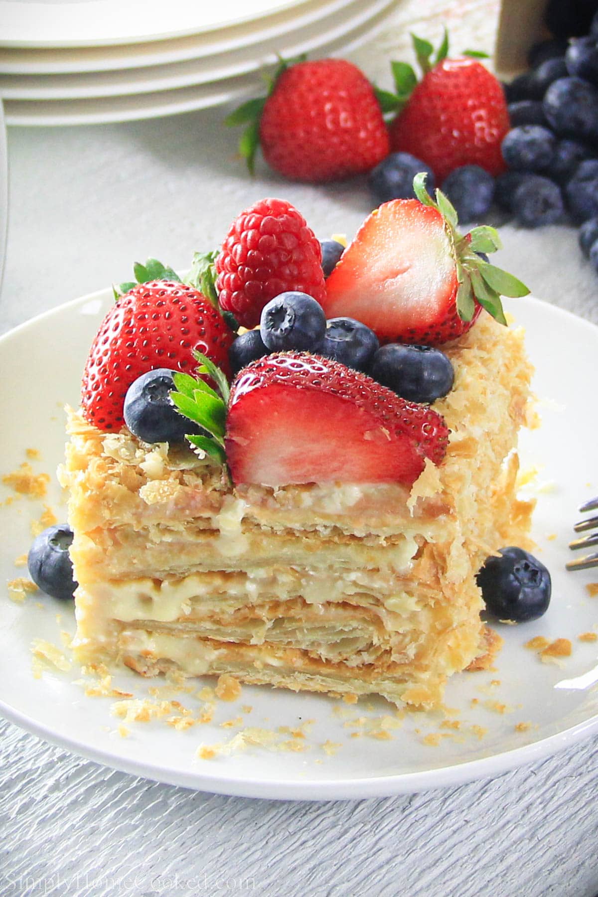 Slice of Easy Napoleon Cake topped with fresh berries.