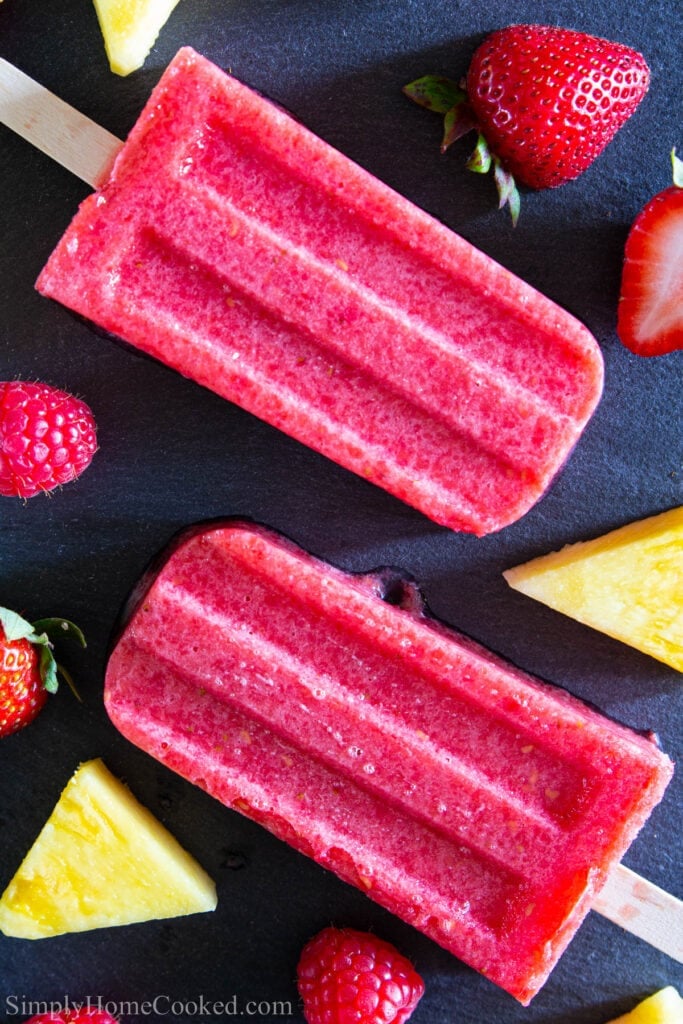 Strawberry Popsicle with pieces of pineapple, strawberries and raspberries.