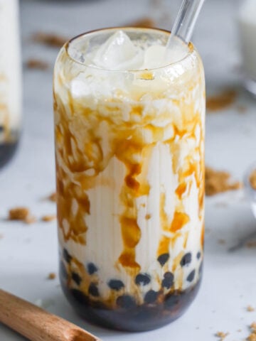 brown sugar boba in a glass cup with a glass straw