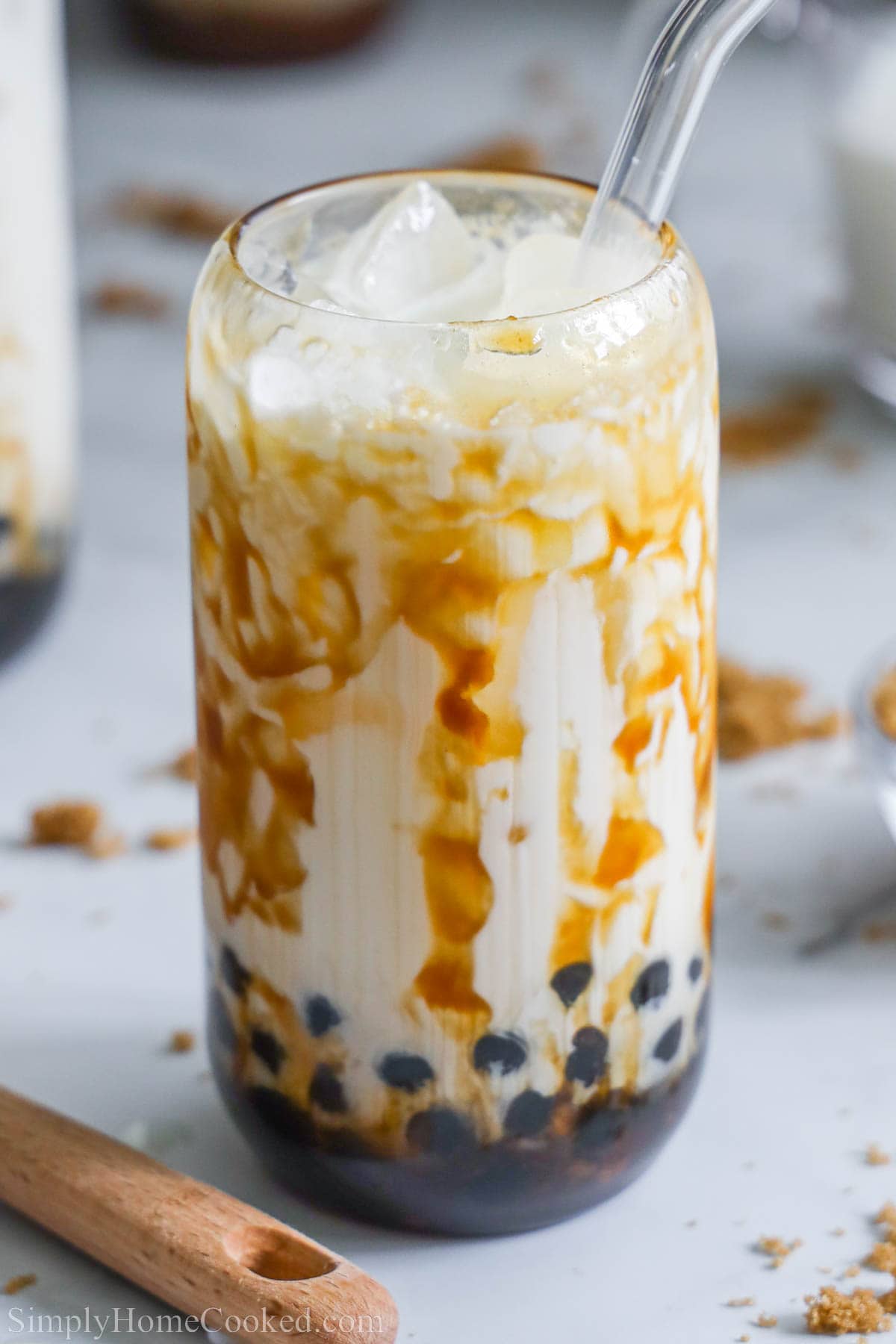 Brown sugar boba in a glass cup with a glass straw