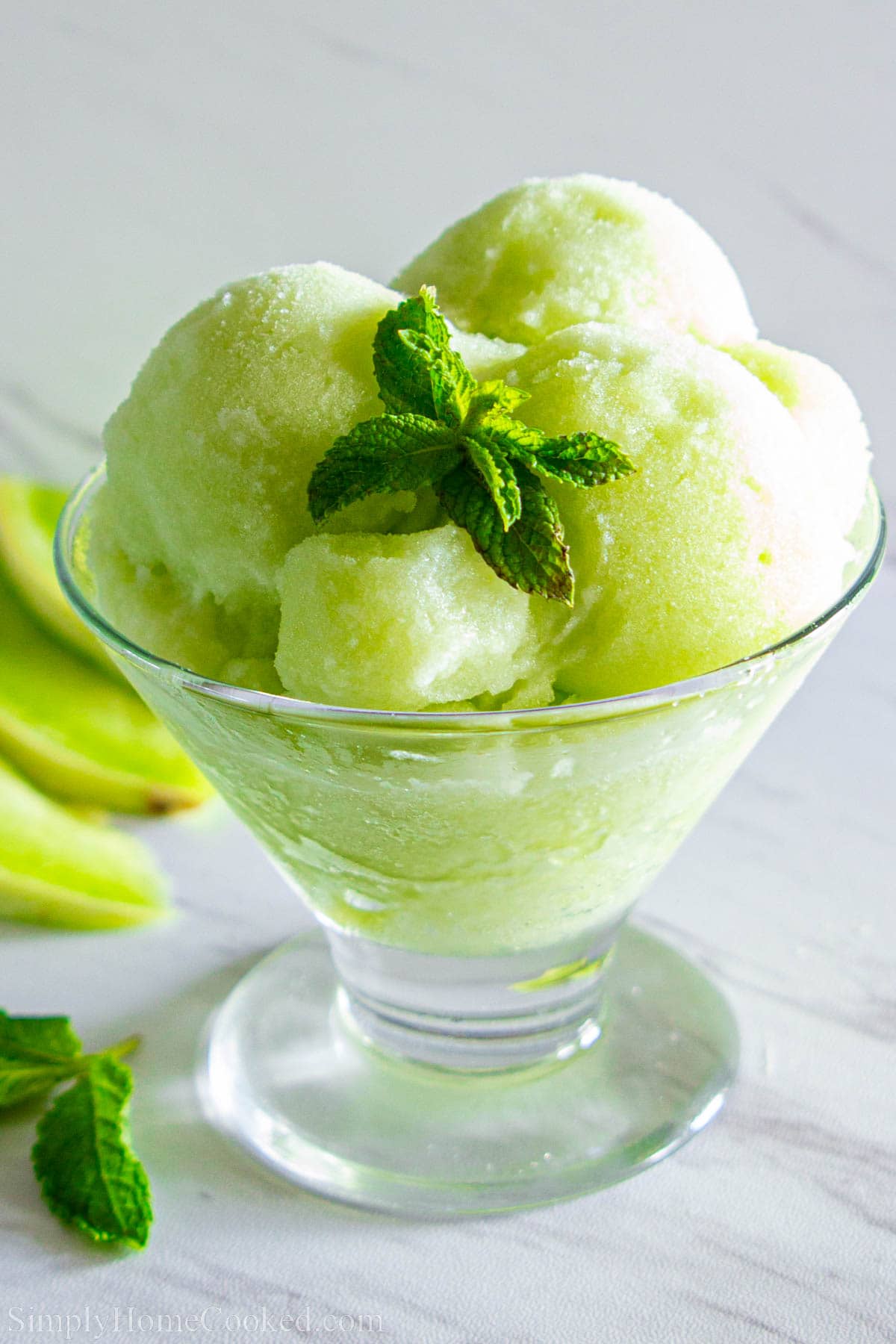 Honeydew Melon Sorbet scooped into a bowl and topped with mint.