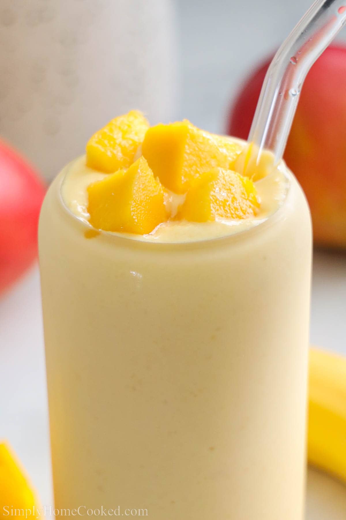 Close up of a Mango Smoothie topped with mango chunks. 