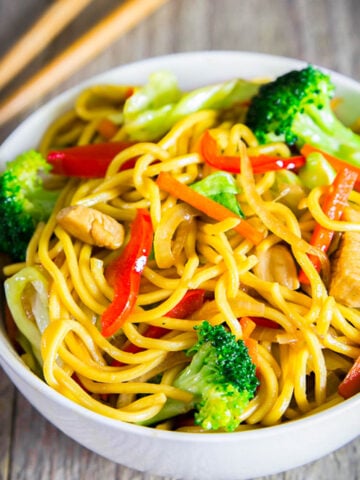 Close up of Chicken Chow Mein with peppers, broccoli, carrots and more in a bowl.