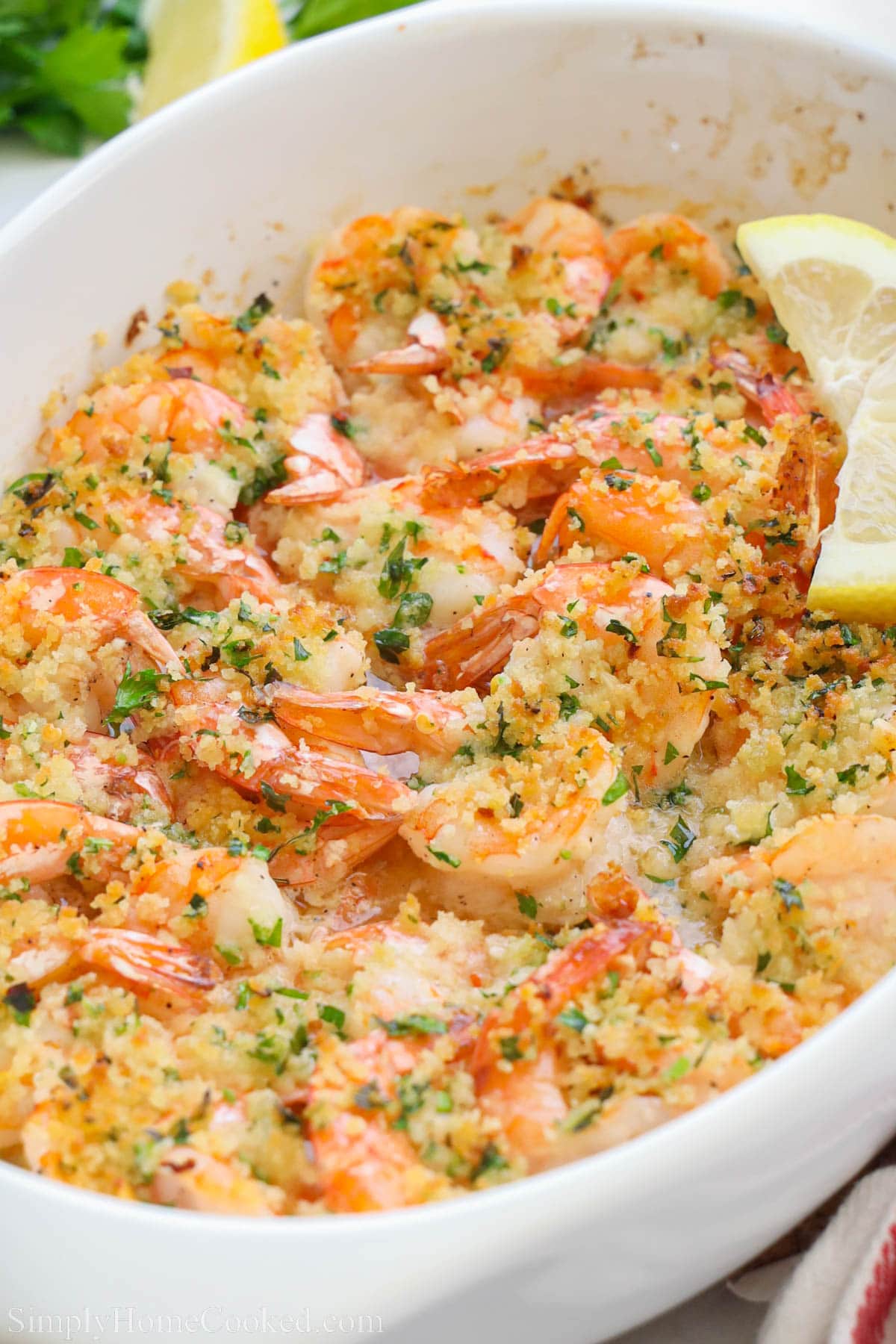 Close up of Baked Shrimp Scampi in a baking dish with lemon slices.