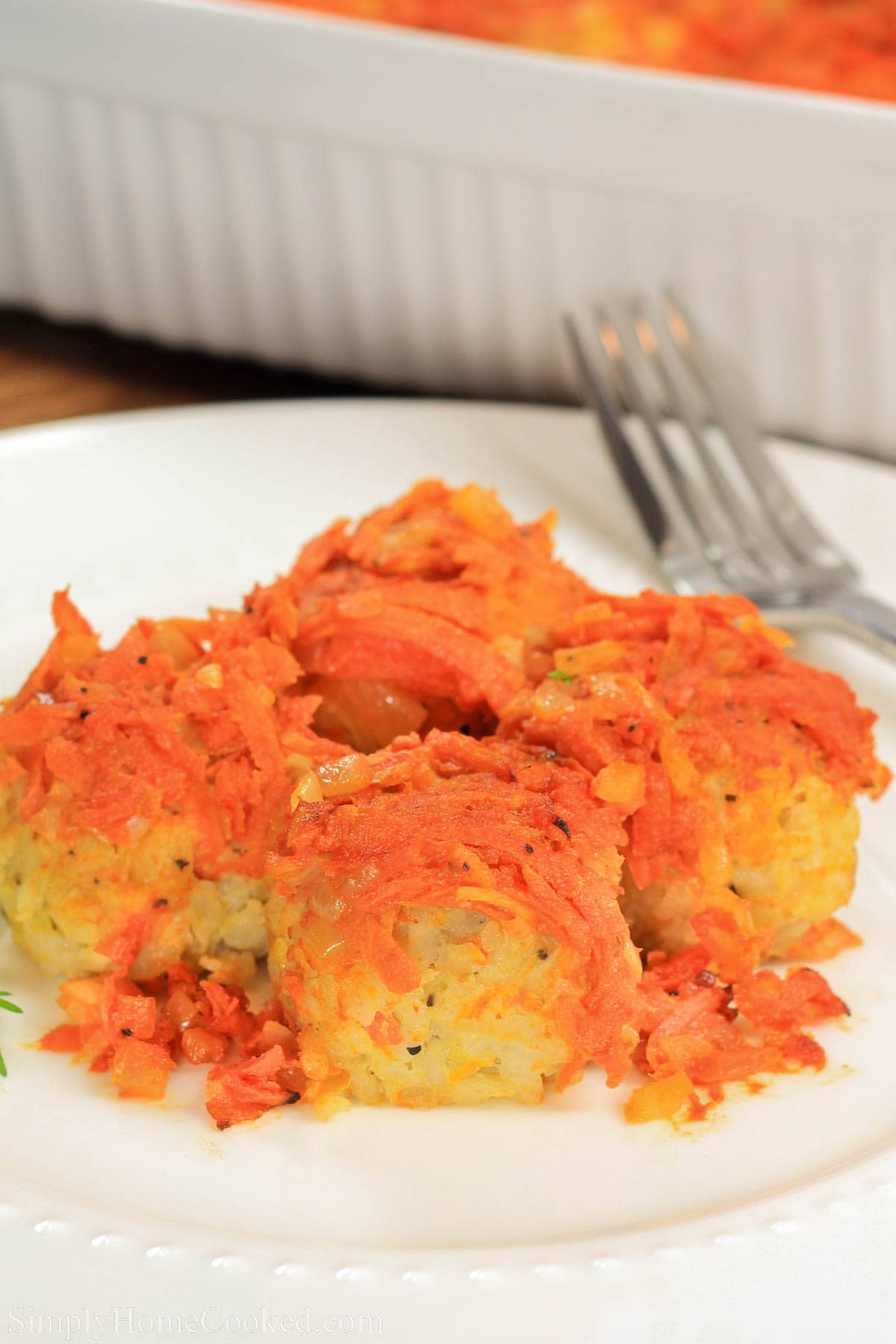Lazy Cabbage Rolls covered with sauteed onions and carrots on a plate with a fork.