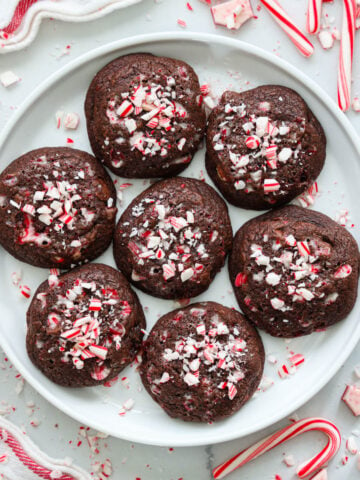 Plate of Chocolate Peppermint Cookies with candy canes nearby.