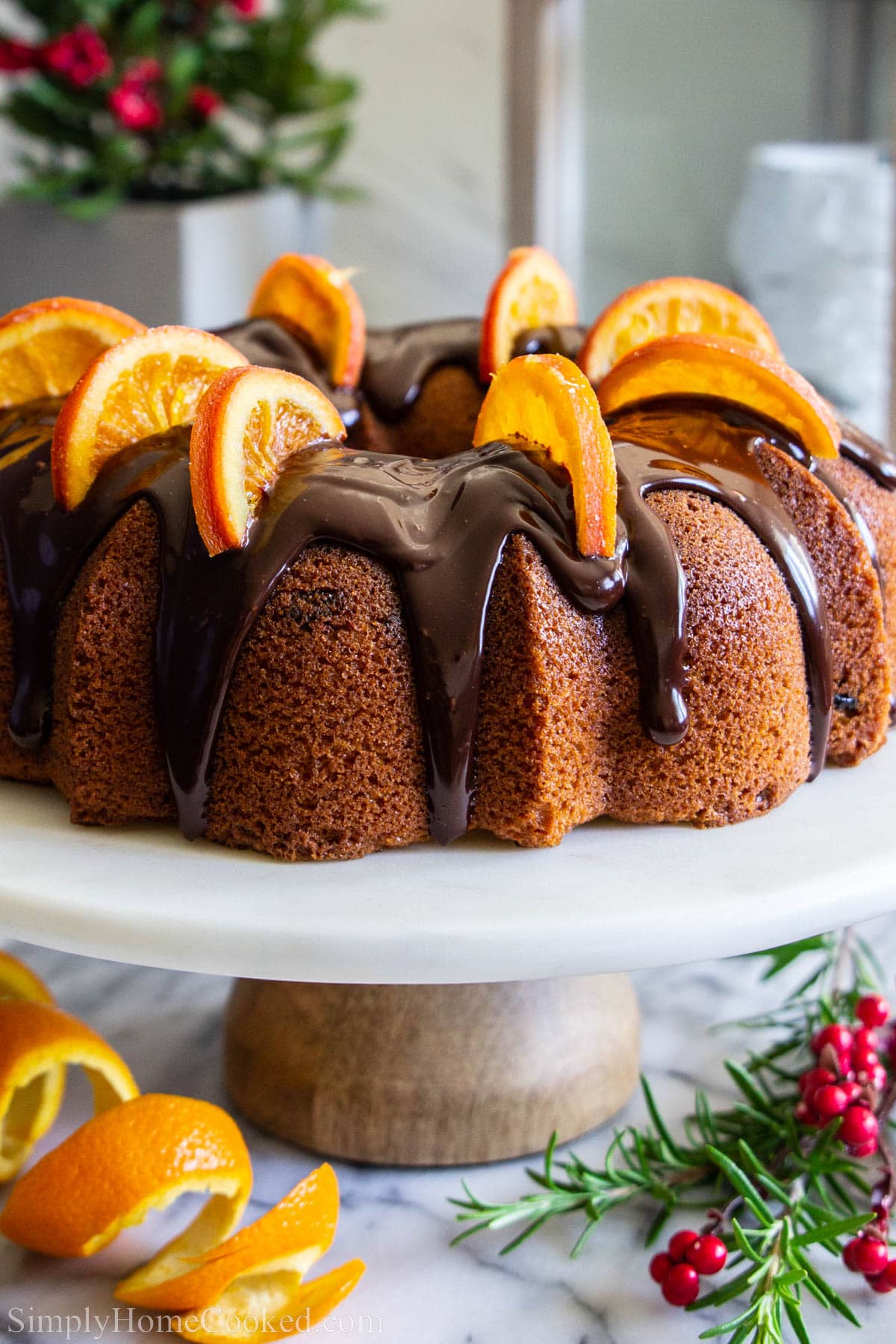 Cranberry Orange Bundt Cake topped with chocolate ganache and orange slices. 