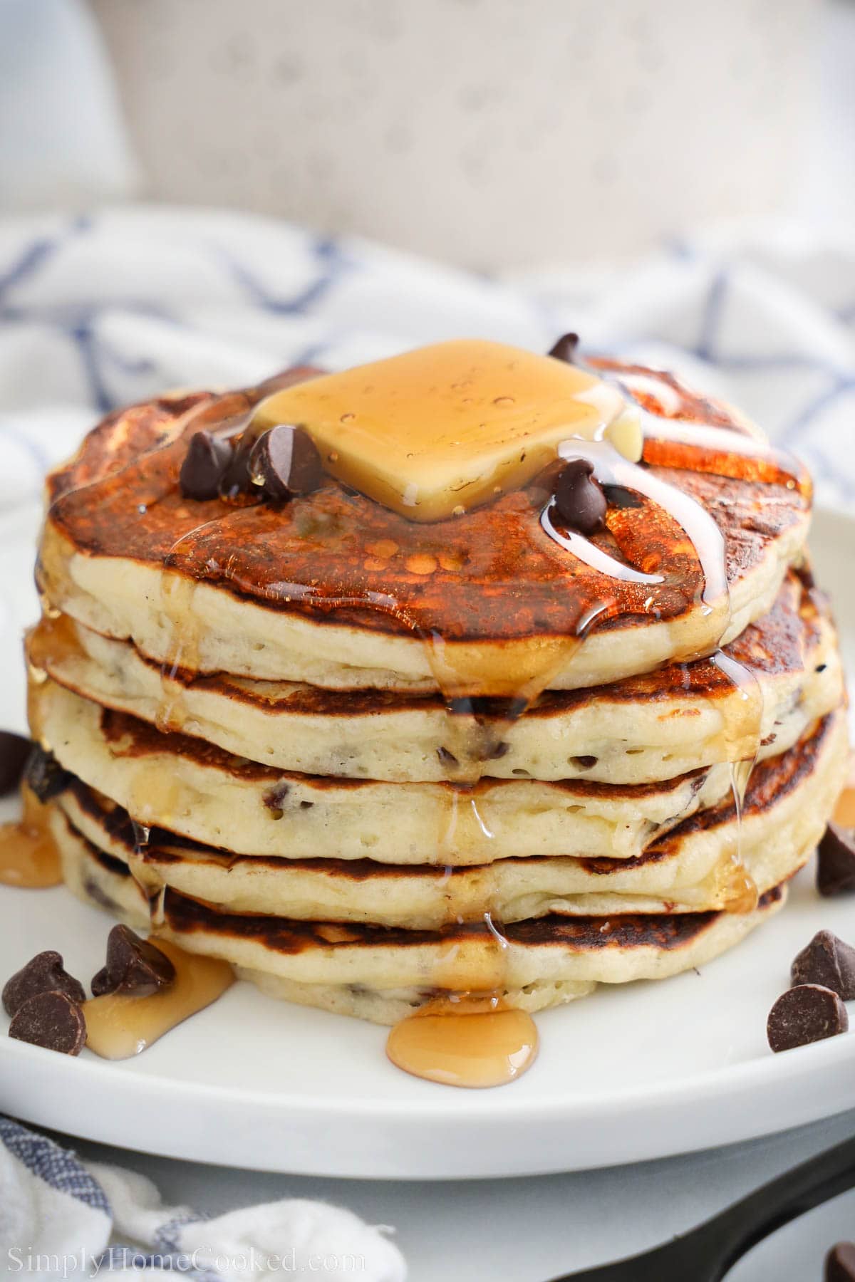 Stack of Chocolate Chip Pancakes with butter and syrup on top.