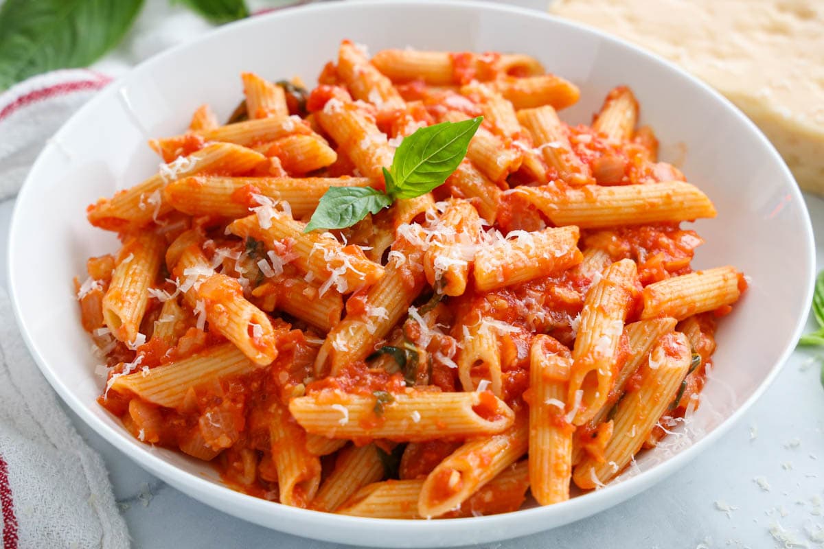 Bowl of Penne Pomodoro topped with fresh basil.