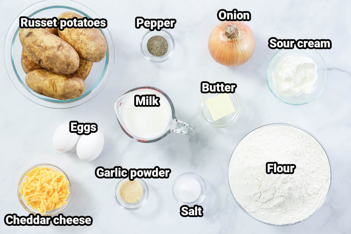 Ingredients for Potato Pierogi: russet potatoes, salt, pepper, onion, garlic powder, milk, eggs, cheddar cheese, flour, and sour cream. 