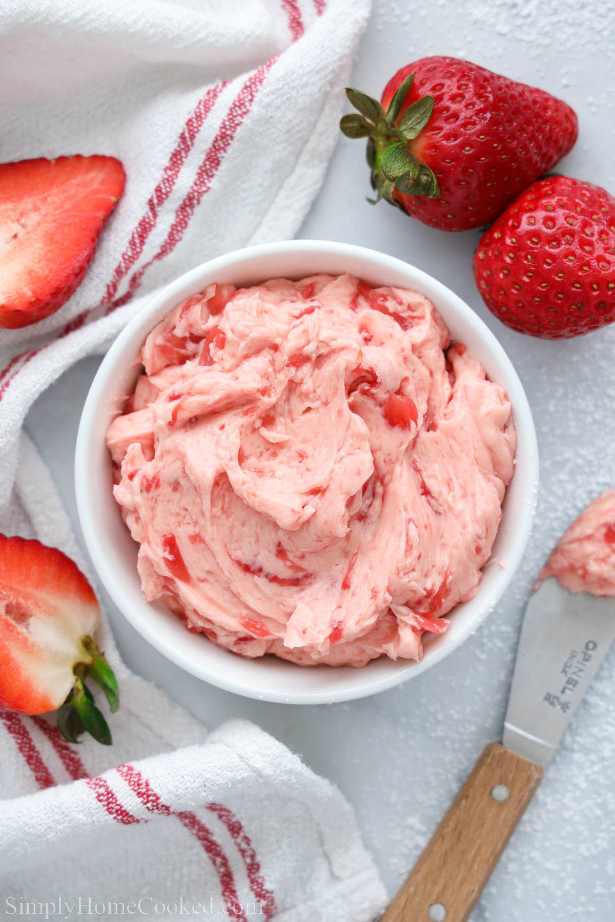 Bowl of Strawberry Butter with a knife and strawberries nearby.