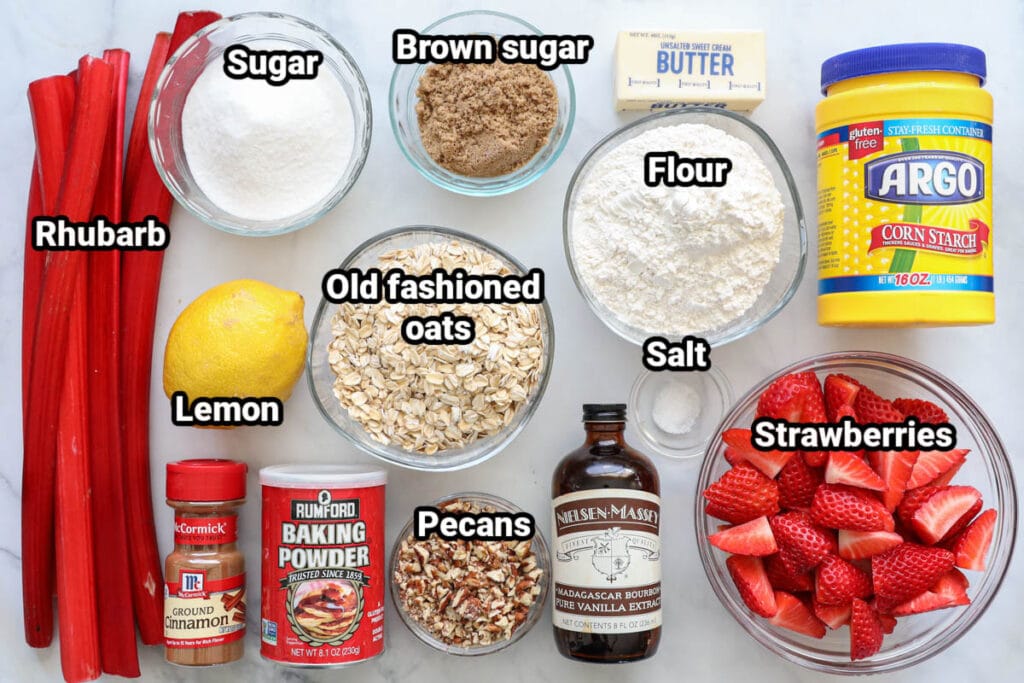 Ingredients for Strawberry Rhubarb Crisp: rhubarb, sugar, brown sugar, flour, butter, corn starch, strawberries, salt, vanilla, pecans, old fashioned oats, lemon, baking powder, and cinnamon.