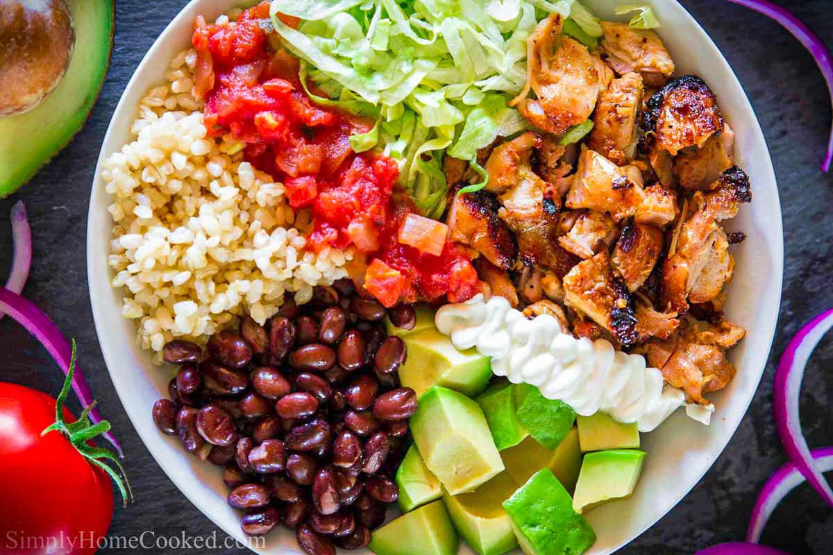 Chipotle Chicken Bowl with chicken, sour cream, avocado, black beans, brown rice, salsa, and lettuce.