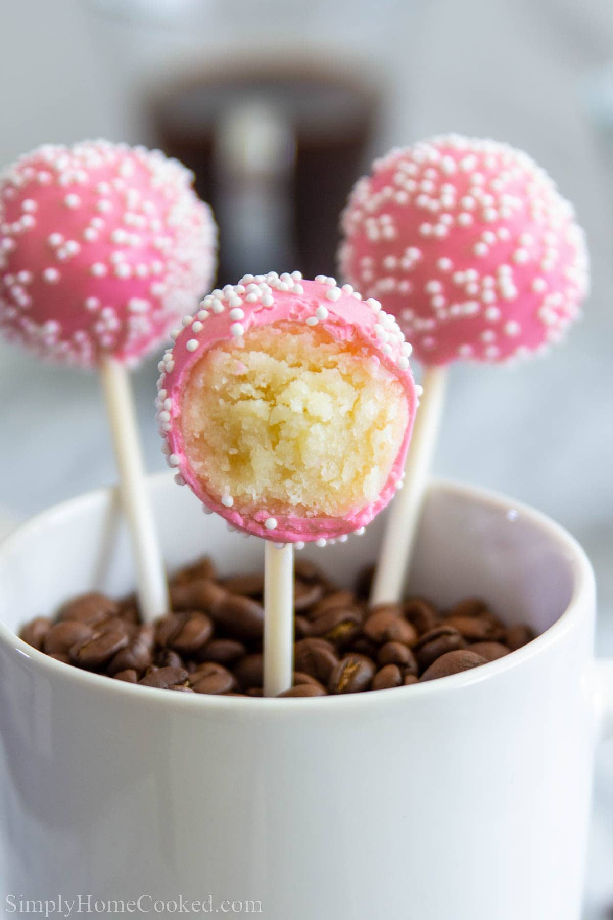 Close up of Vanilla Cake Pops, one missing a bite. 