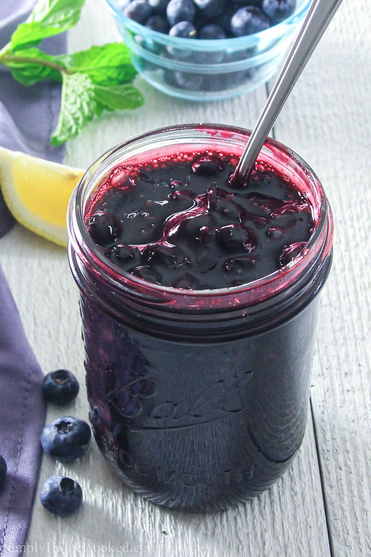 Jar of Blueberry Pie Filling with a spoon in it. 