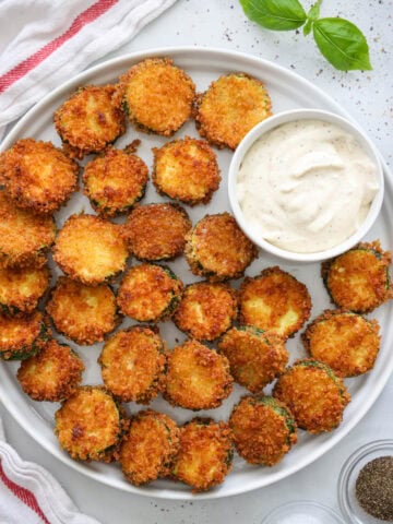 Fried Zucchini on a plate with garlic aioli sauce.