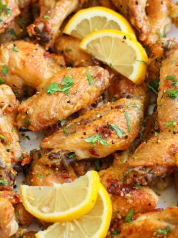 Close up of Lemon Pepper Wings with lemon slices.