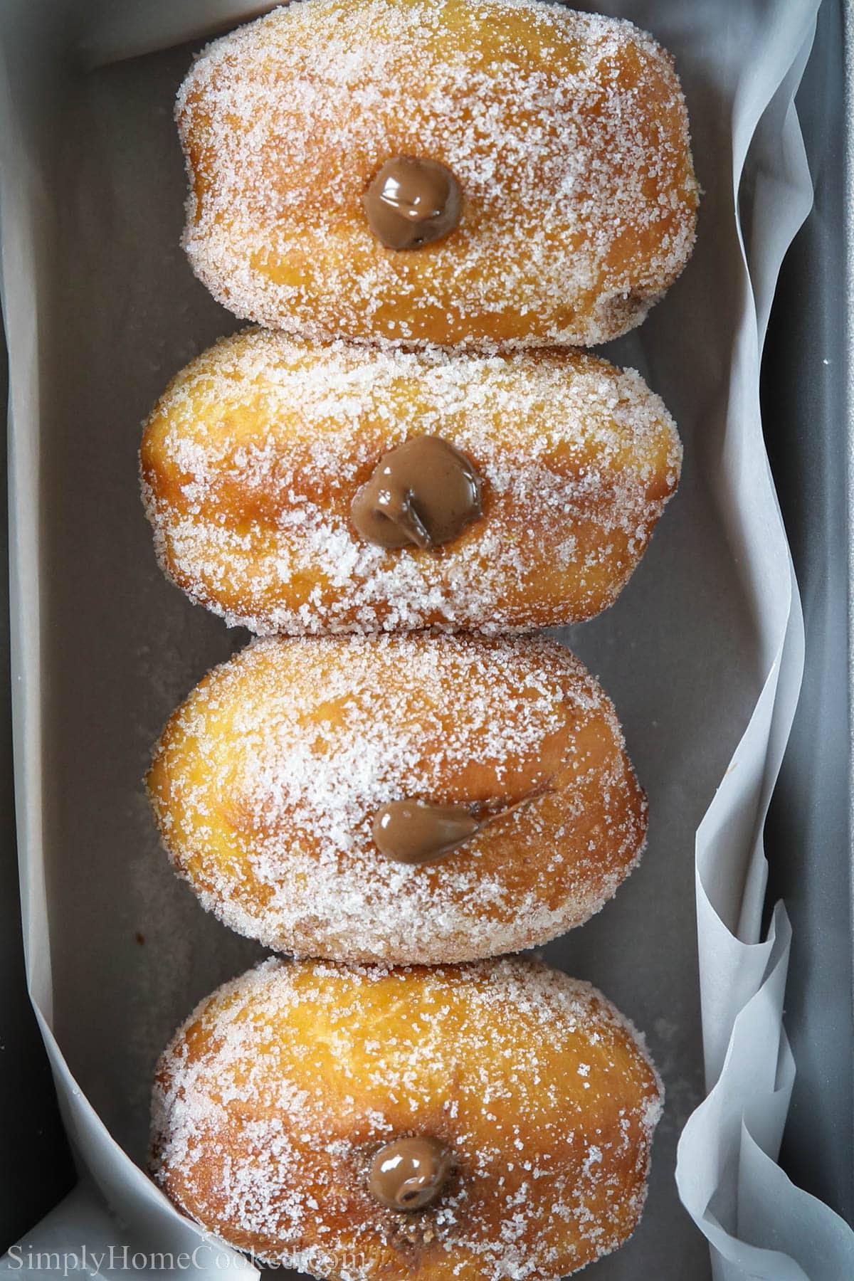 Brioche Donuts covered in sugar and with a Nutella filling in a pan.