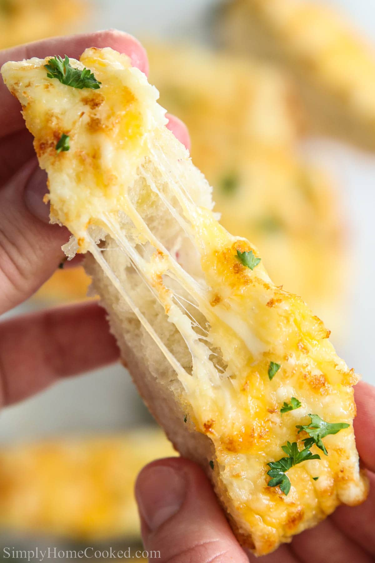 Piece of Garlic Cheese Bread being pulled apart. 