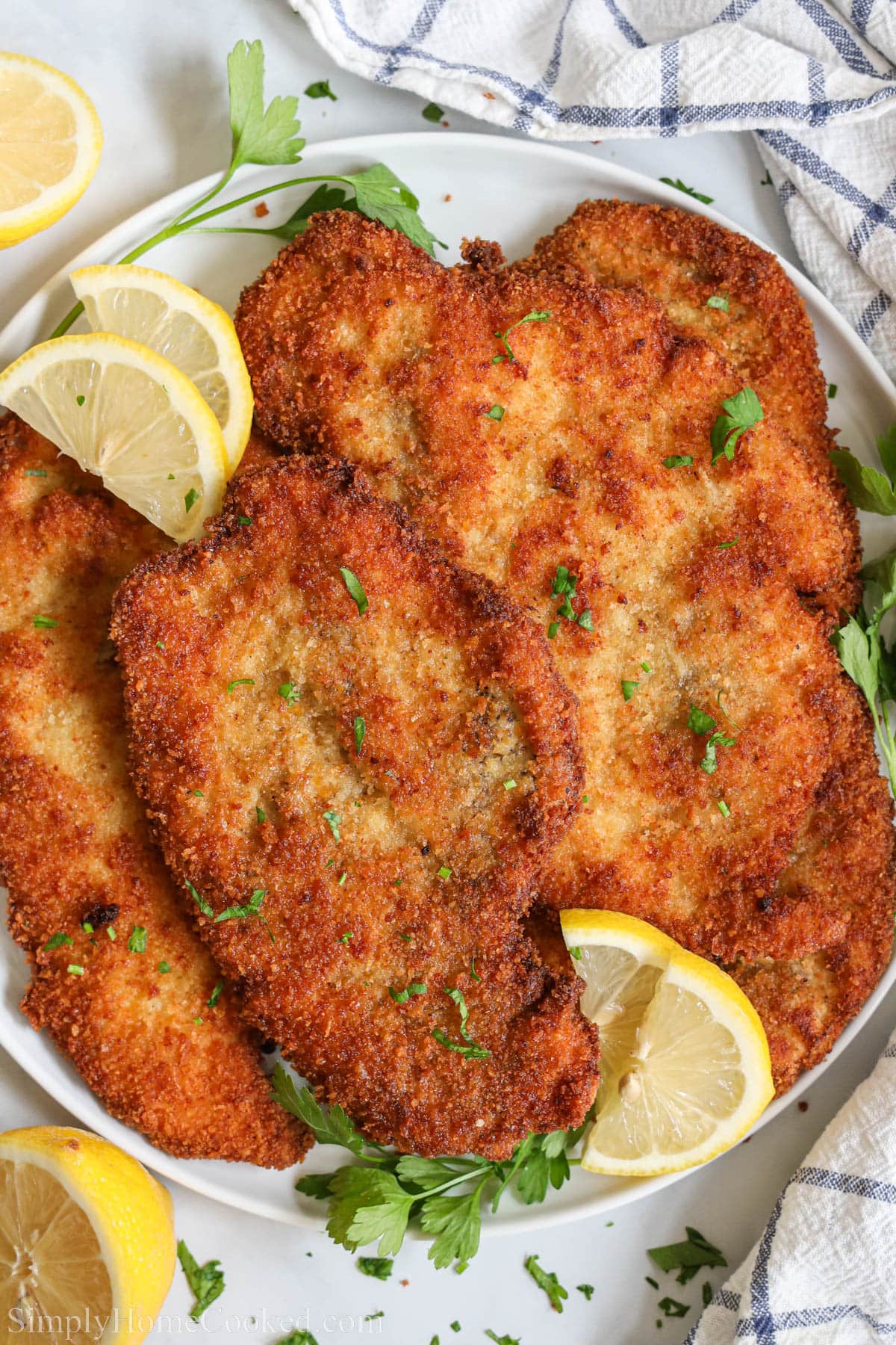 Chicken Cutlets topped with chopped parsley and lemon slices.