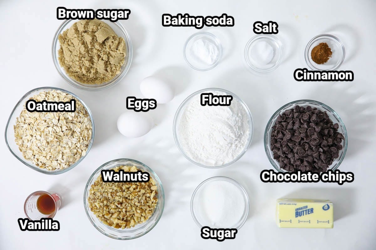 Ingredients for Oatmeal Chocolate Chip Cookies: oatmeal, brown sugar, walnuts, vanilla, eggs, baking soda, salt, flour, cinnamon, chocolate chips, sugar, and butter. 