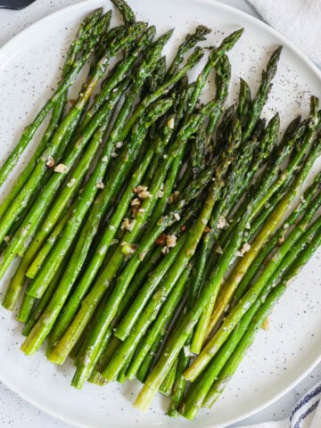 Oven Roasted Asparagus topped with minced garlic.