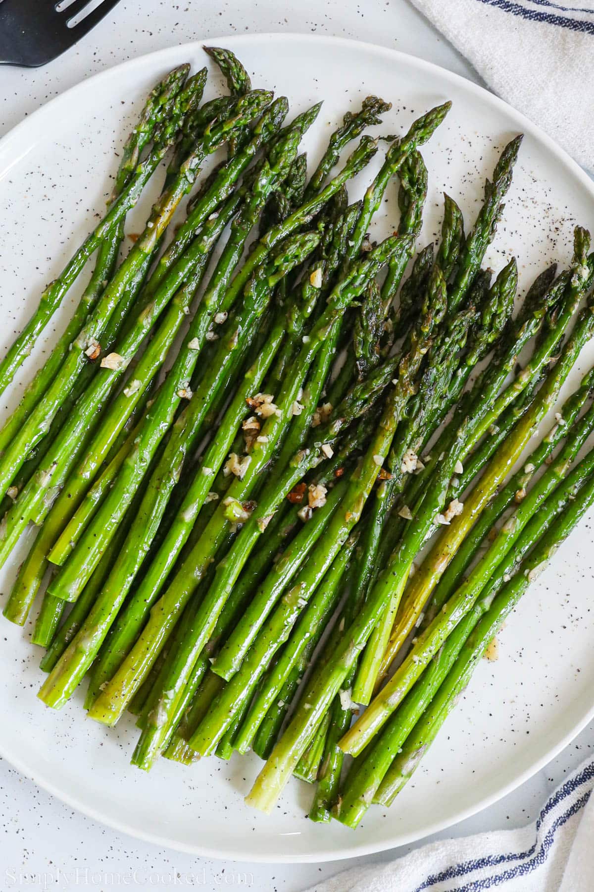 Oven Roasted Asparagus topped with minced garlic.