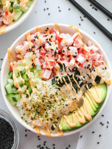 Overview of California Roll Sushi Bowl drizzled with spicy mayo, furikake, and sesame seeds.