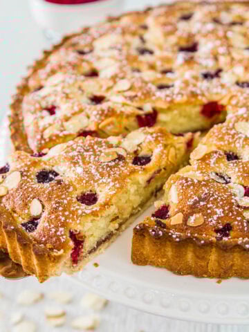 Bakewell Tart with a slice being removed.