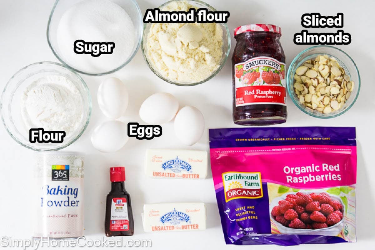 Ingredients for a Bakewell Tart filling: almond flour, sugar, all-purpose flour, eggs, butter, baking soda, almond extract, sliced almonds, and frozen raspberries.