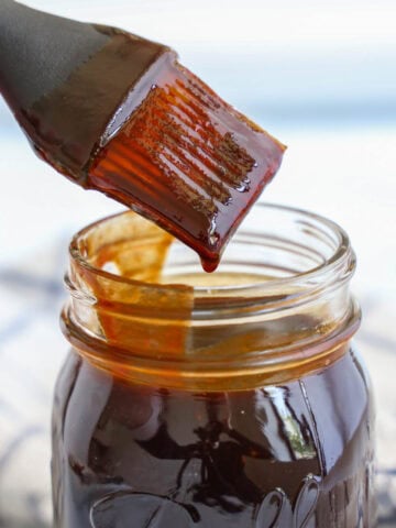 BBQ Sauce in a mason jar with a brush dipped inside.