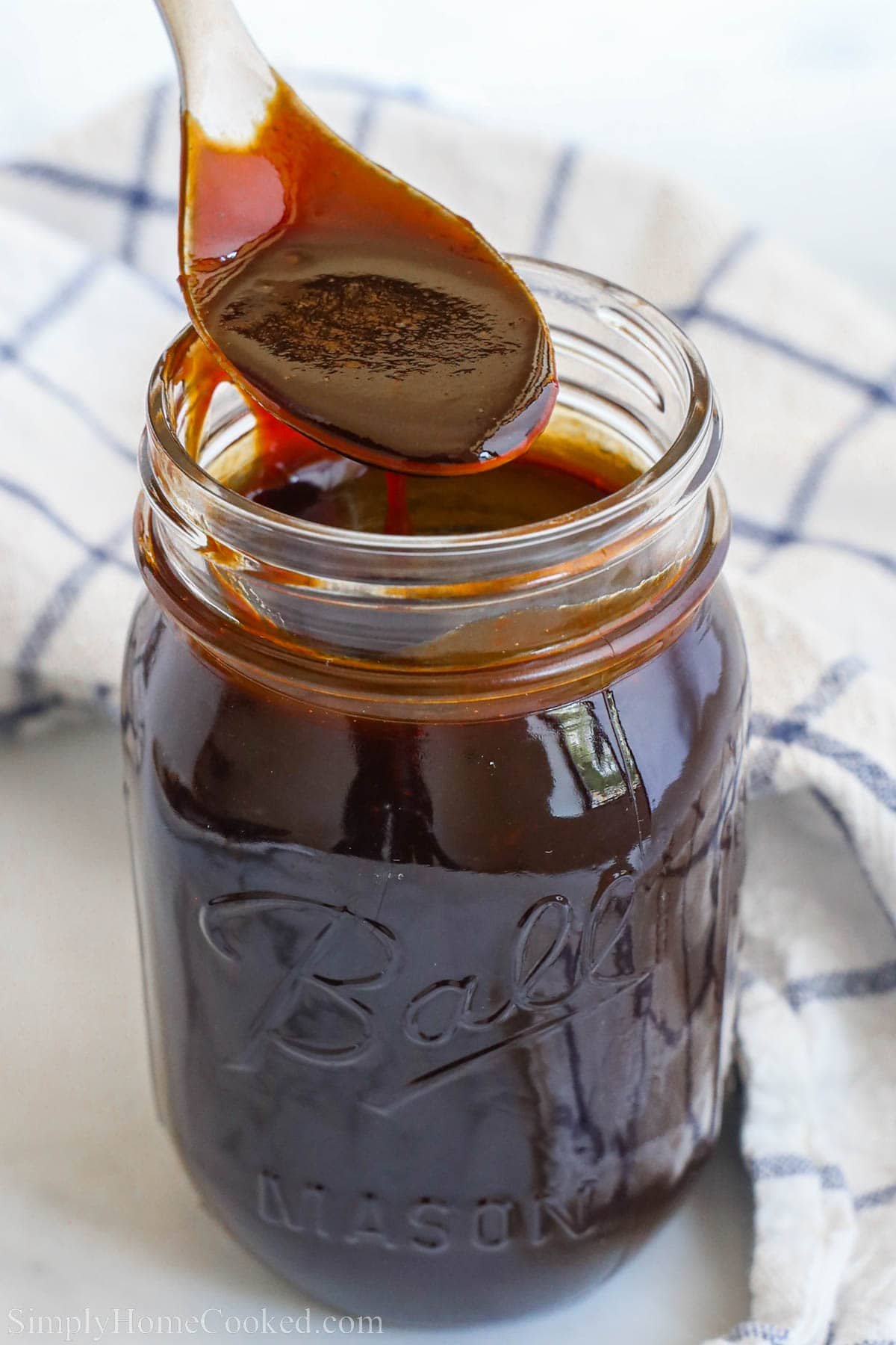 BBQ Sauce in a mason jar with a spoon. 