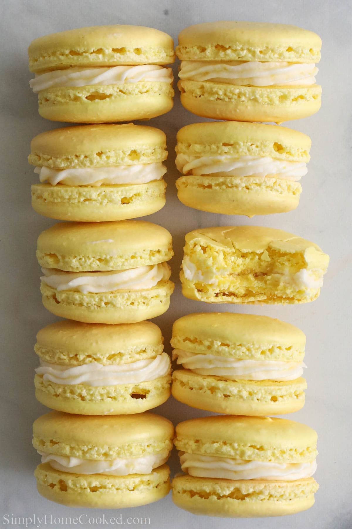 Lemon Macarons lined up, one missing a bite.