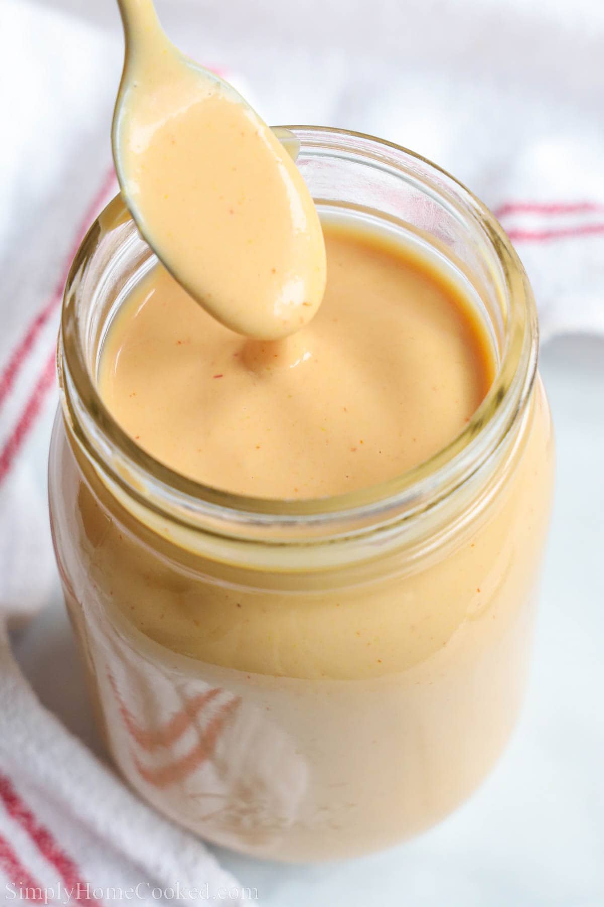 Close up of a jar of Burger Sauce with a spoon.