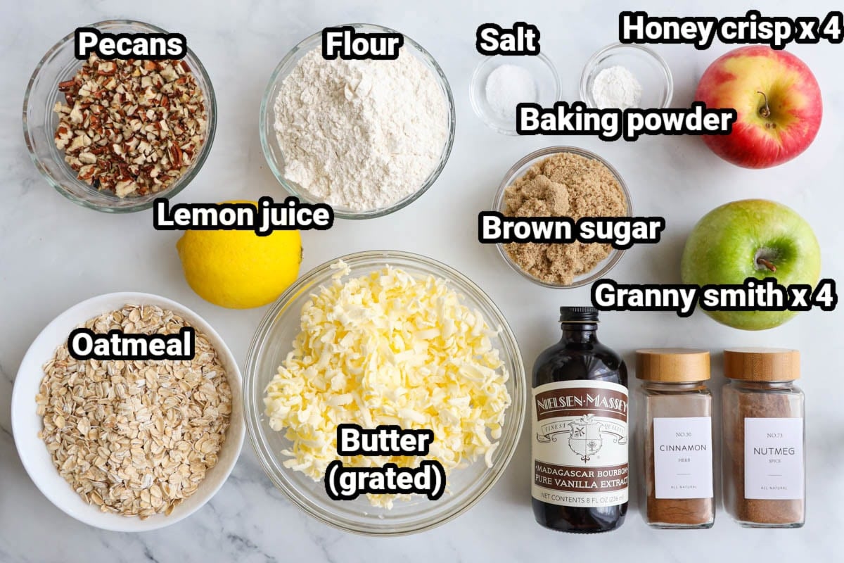 Ingredients for an Apple Crisp: oatmeal, flour, pecans, lemon juice, salt, cinnamon, nutmeg, brown sugar, butter, honeycrisp apples, and granny smith apples. 