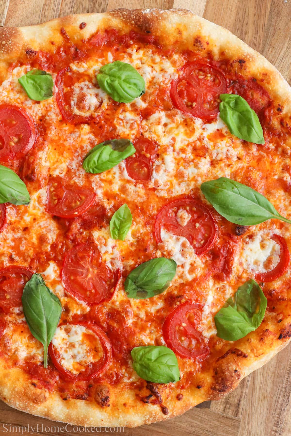 Sourdough Pizza crust topped with red sauce, mozzarella, tomatoes, and fresh basil.