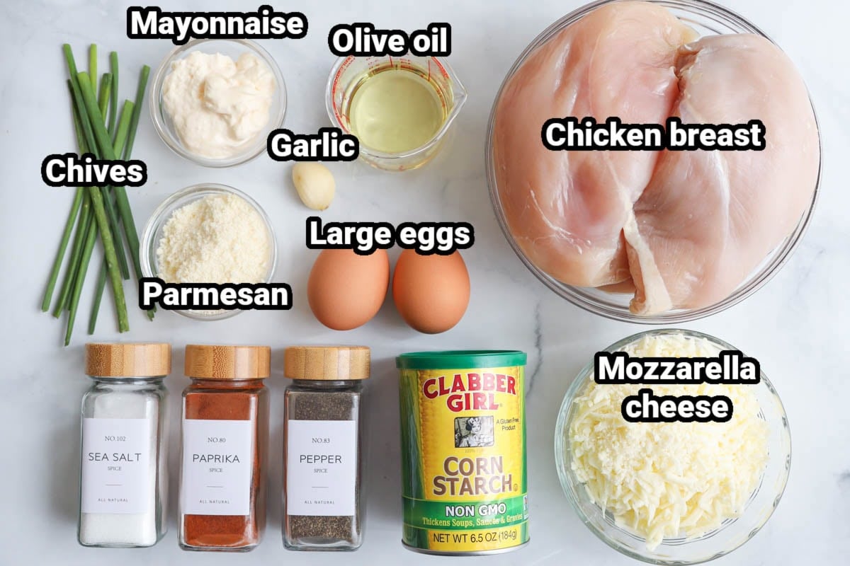 Ingredients for Chicken Fritters: chicken breasts, olive oil, mayonnaise, garlic, chives, parmesan, eggs, mozzarella, cornstarch, pepper, sea salt, and paprika.