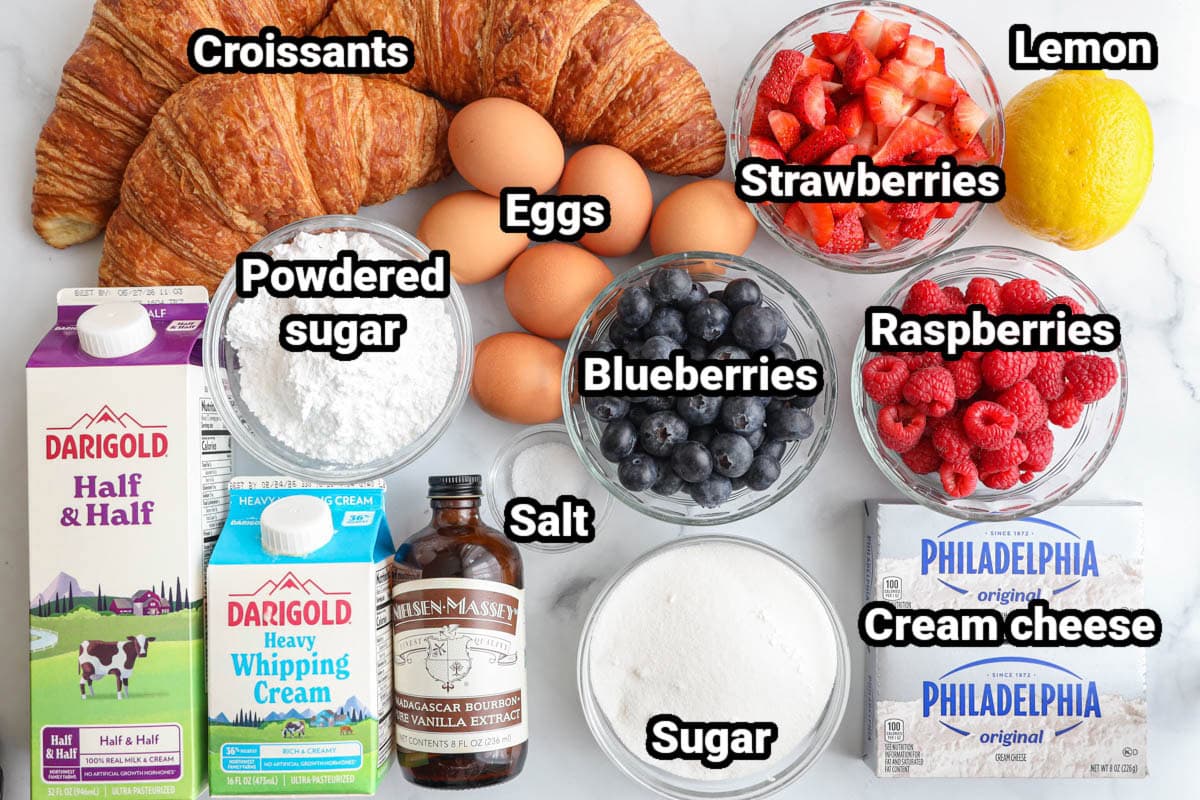 Ingredients for a Sweet Croissant Breakfast Casserole: croissants, eggs, strawberries, raspberries, blueberries, lemon, salt, powdered sugar, half & half, heavy cream, vanilla extract, sugar, and cream cheese.