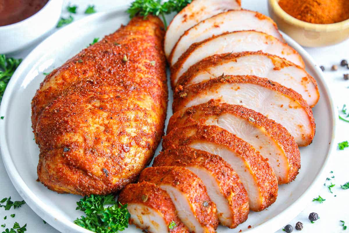 Smoked Chicken Breasts arranged on a plate with one of them sliced.
