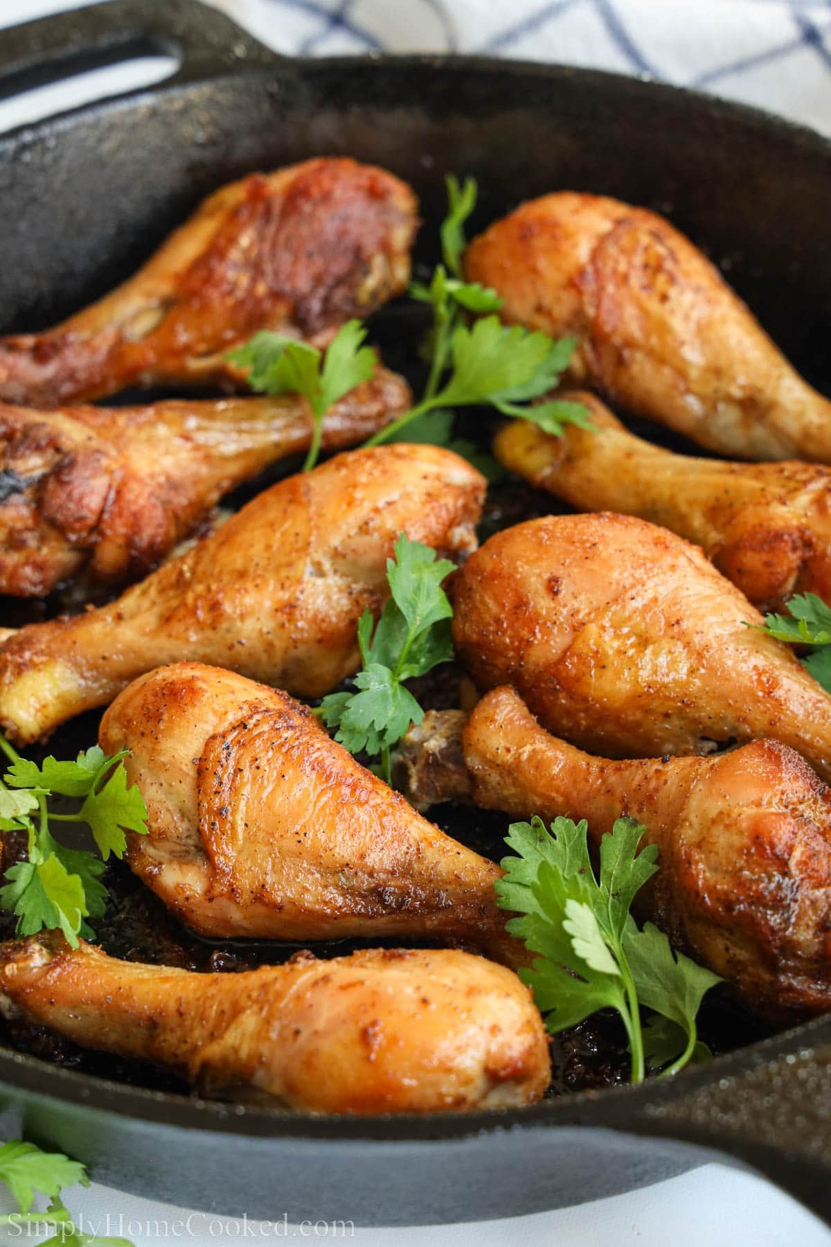 Baked Chicken Drumsticks in a cast iron skillet with parsley.