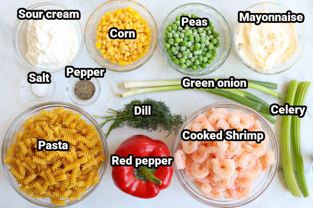 Ingredients for Shrimp Pasta Salad: sour cream, corn, peas, mayonnaise, green onions, salt, pepper, dill, celery, cooked shrimp, red pepper, and pasta.