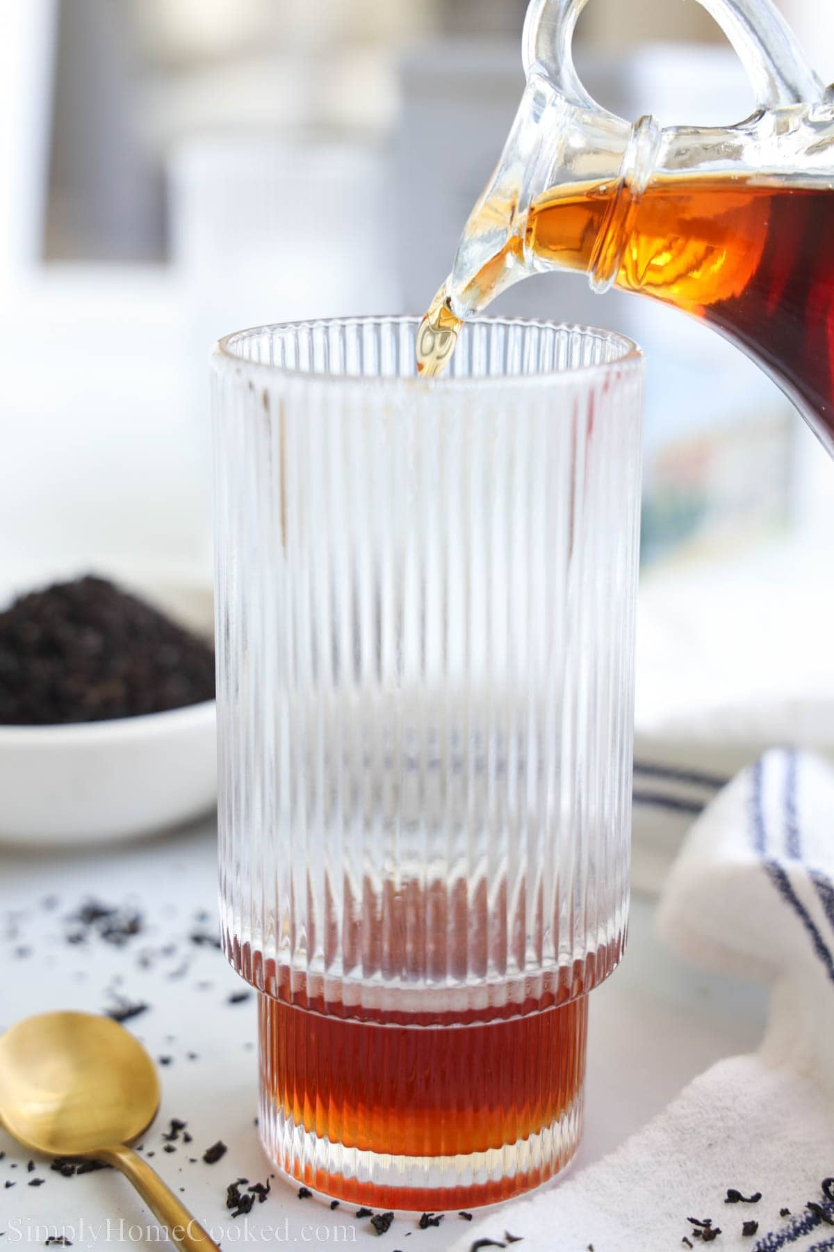 Pouring Earl Grey Syrup into a glass.