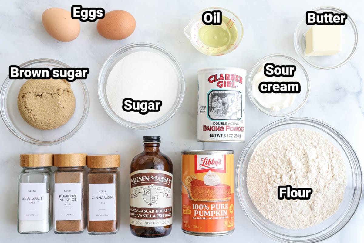 Ingredients for Pumpkin Muffins: flour, sugar, brown sugar, butter, oil, sour cream, baking powder, pumpkin puree, eggs, vanilla extract, pumpkin pie spice, cinnamon, and salt.